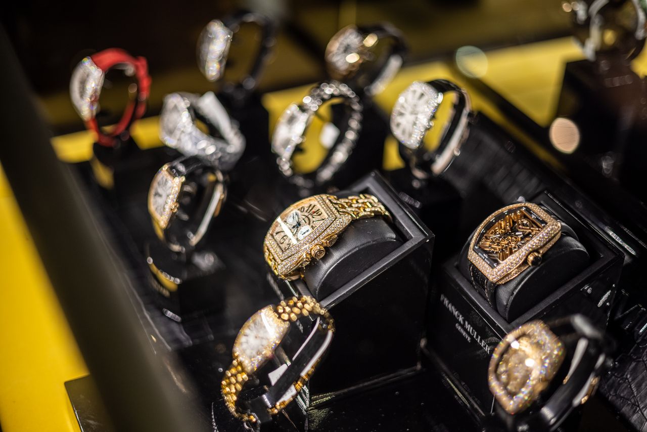 Home A captivating display of opulent gold and diamond watches in a high-end jewelry store setting.