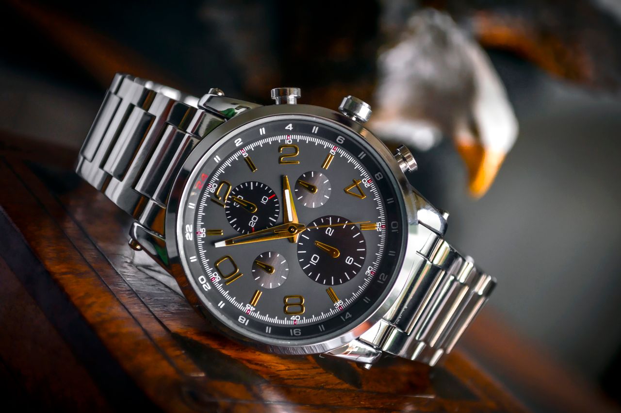 Home Luxury wristwatch with stainless steel bracelet displayed elegantly on a wooden background.